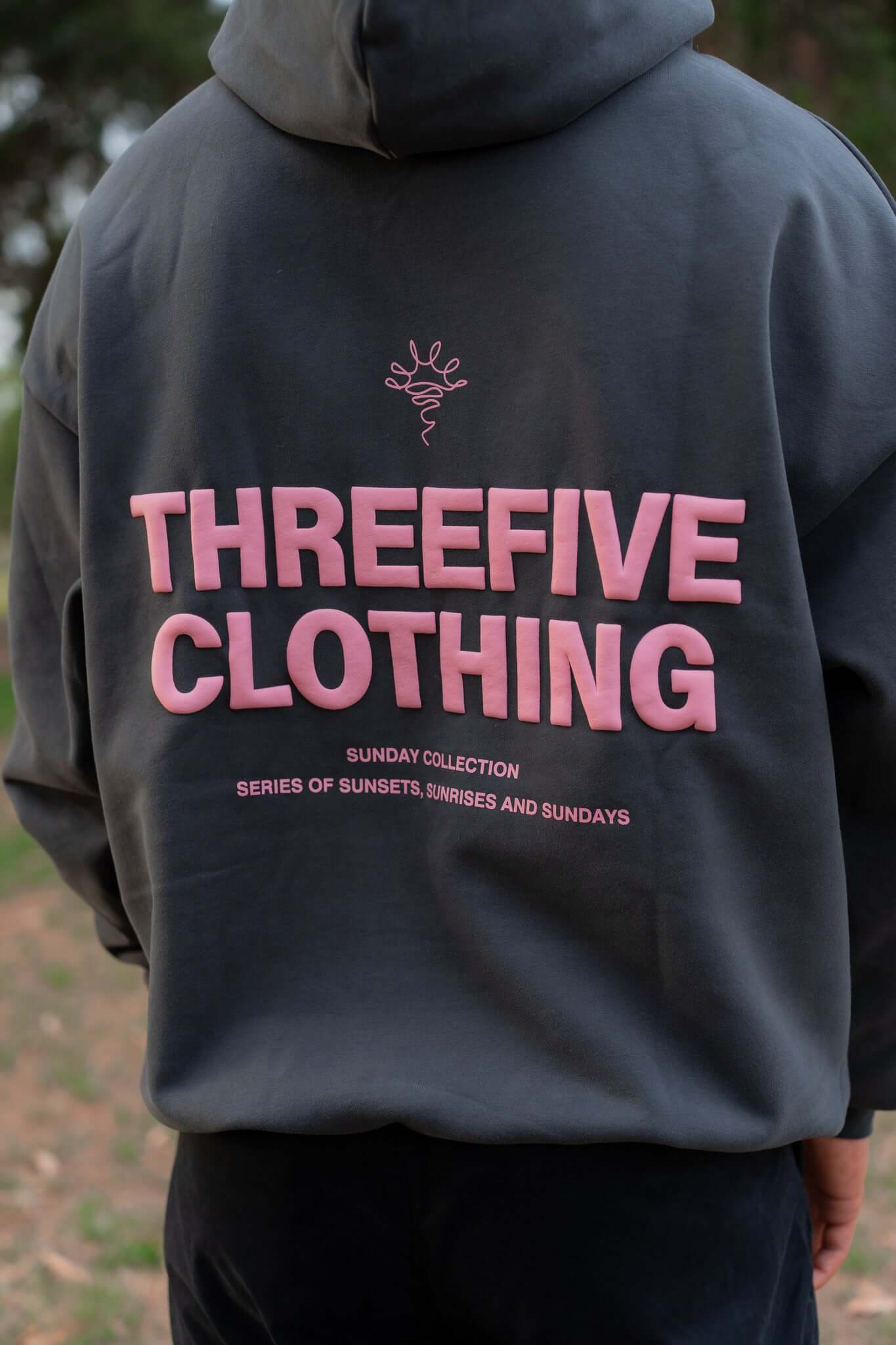 Close up of back of stone coloured hoodie, pink design