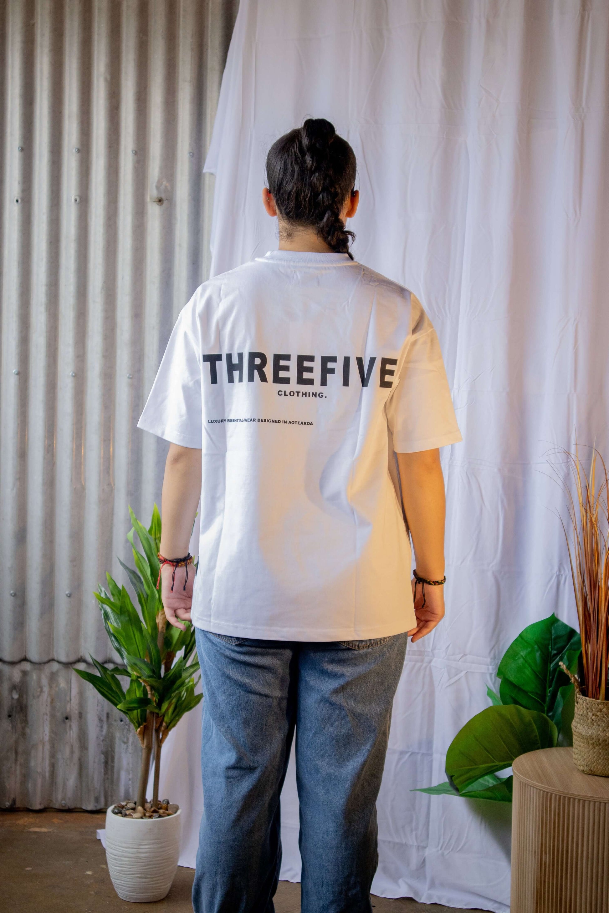 Female wearing blank front white coloured ThreeFive T-shirt, pictured from the back