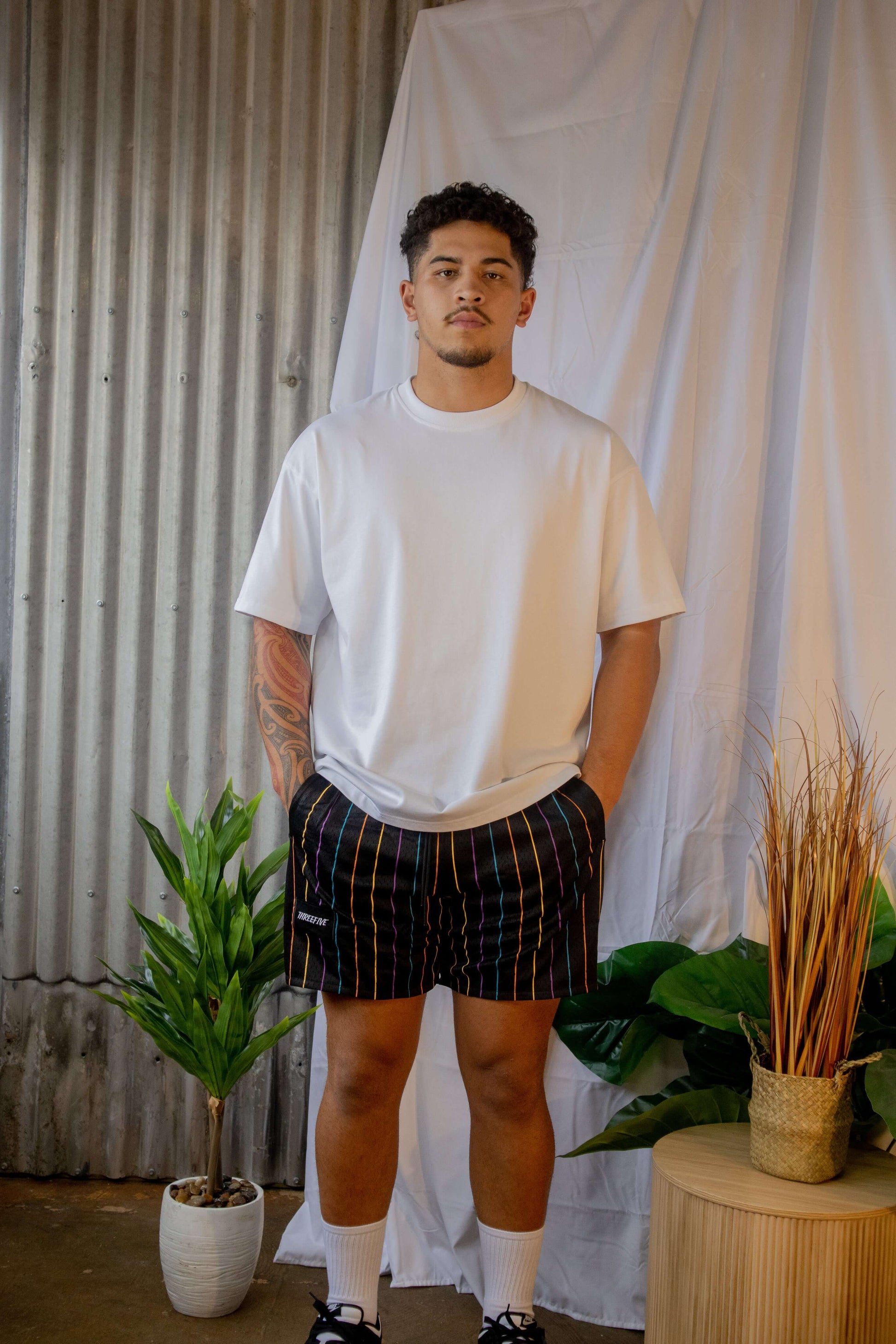 Male posing for photo, wearing black remastered shorts from ThreeFive Clothing
